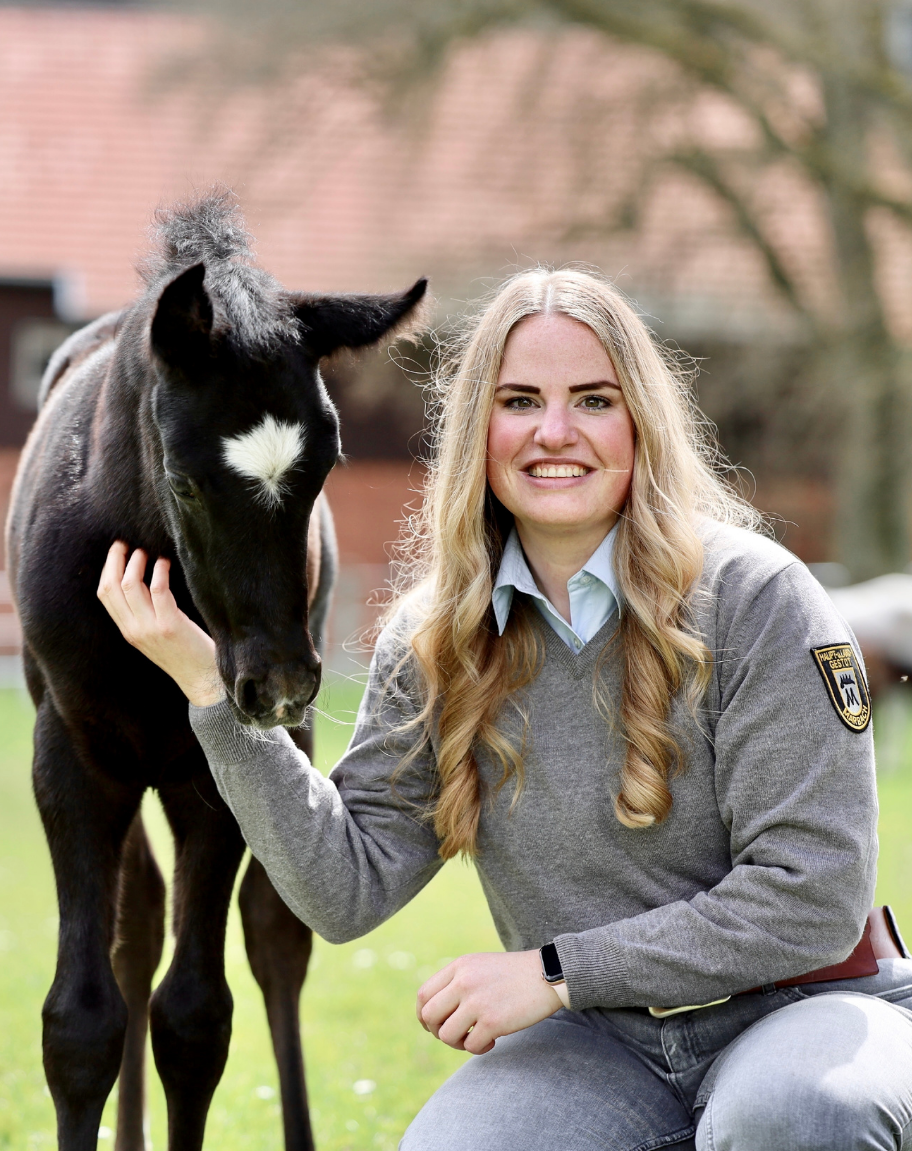 Foto Projektkoordinatorin Madeline Meyer mit Fohlen auf der Weide